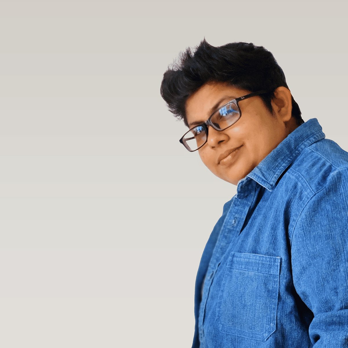 Founder of Das Design Studio wearing a blue shirt and glasses, posing confidently against a clean background